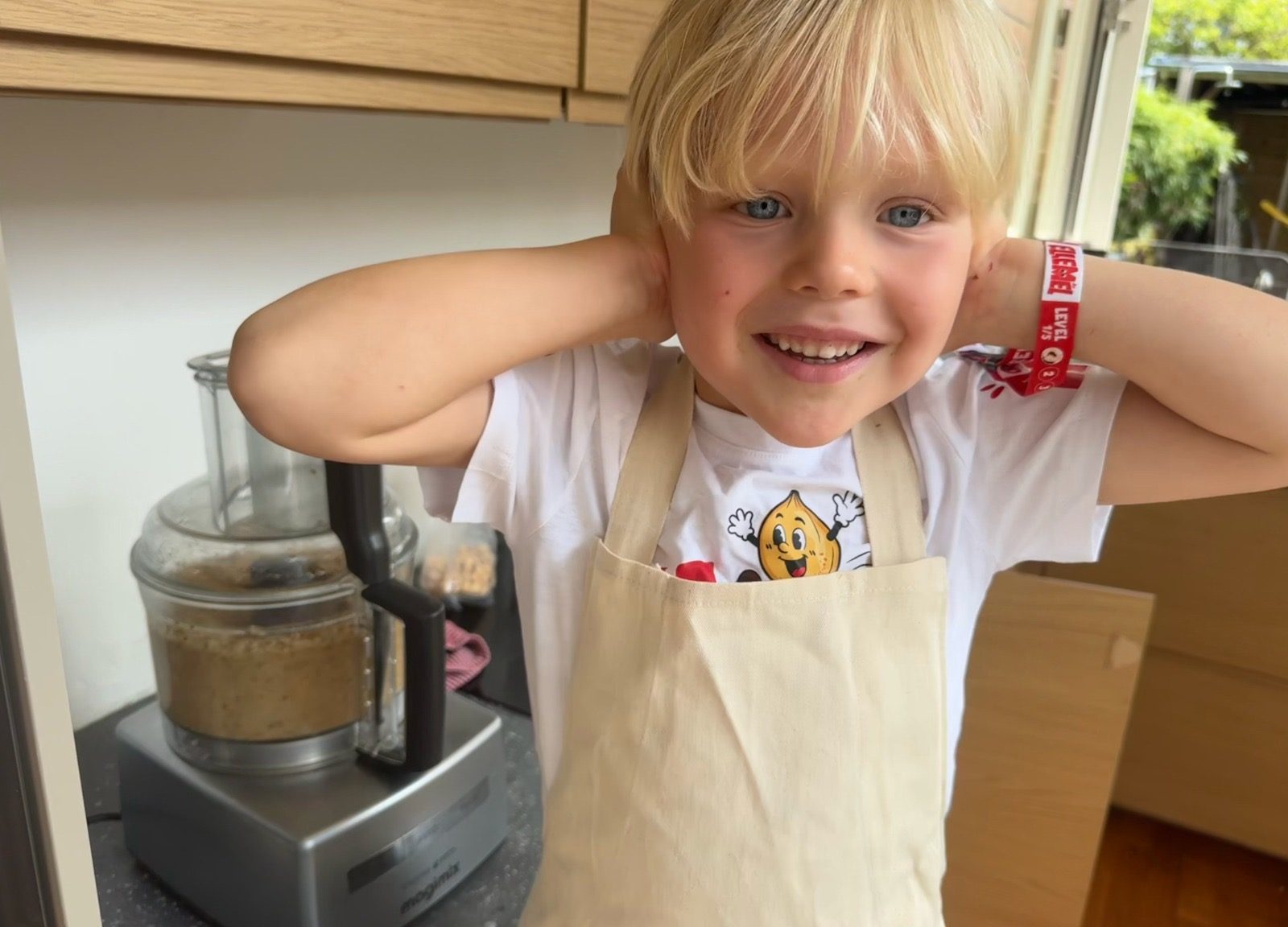 Kind in Ellemel schort helpt met hazelnoten malen